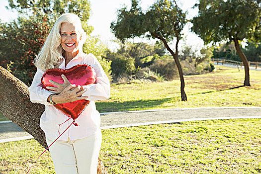 老年,女人,搂抱,红色,心形,气球,公园,洛杉矶,加利福尼亚,美国