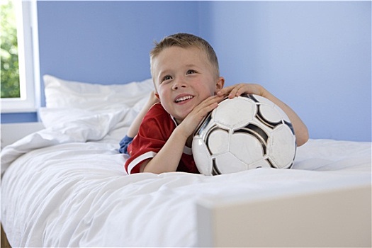男孩,4-6岁,俯卧,床,休息,下巴,足球,微笑