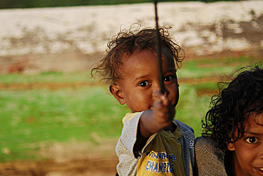 portrait,of,small,dark,skinned,timorese,boy,holding,baby