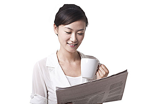 喝茶看英文报纸的商务女性