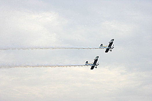 首届重庆大足航展上,英国御风飞行队的双翼飞机在进行两机相交空中芭蕾特技飞行表演