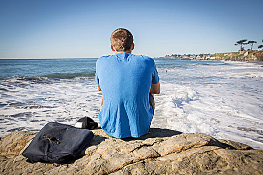 男青年,坐,石头,向外看,海洋,后视图
