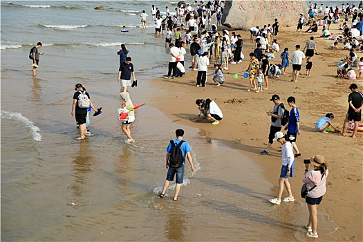 山东省日照市,太公岛游人如织,赶海拾贝做游戏乐在其中