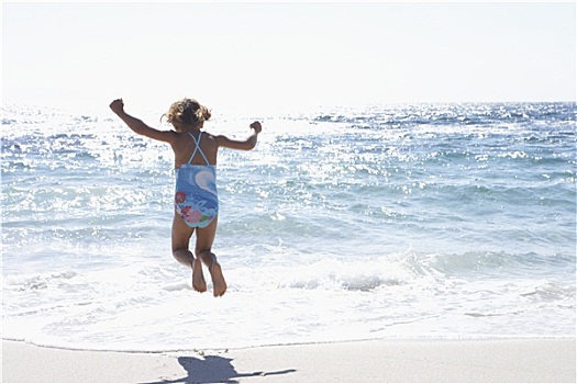 女孩,3-5岁,穿,泳衣,跳跃,高处,海浪,沙滩,后视图,海洋,闪闪发光,阳光