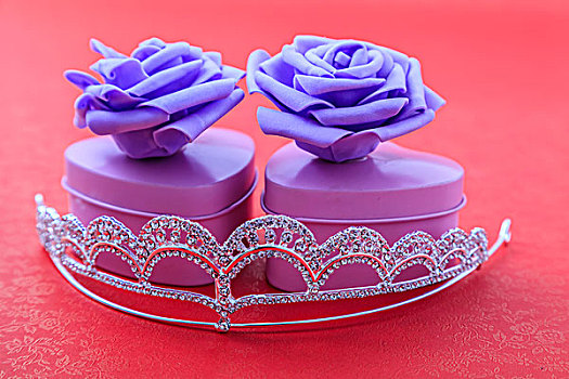 水晶皇冠和有紫色玫瑰花的心形礼盒
