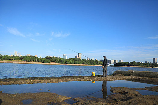 山东省日照市,秋高气爽的清晨,市民湖边垂钓扒蛤蜊成为一道独特景观