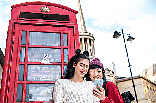 两个,年轻,时髦,女人,看,智能手机,红色,电话亭,伦敦,英国