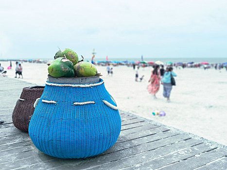 海滩边装满椰子的蓝色编织箩筐,广西北海银滩夏日风光