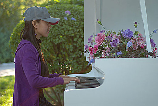 一名年轻女性弹白色的钢琴