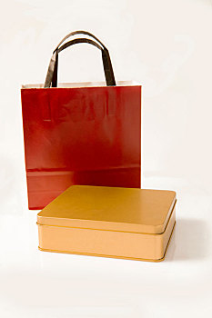 金色礼盒与红色手提袋在白色背景