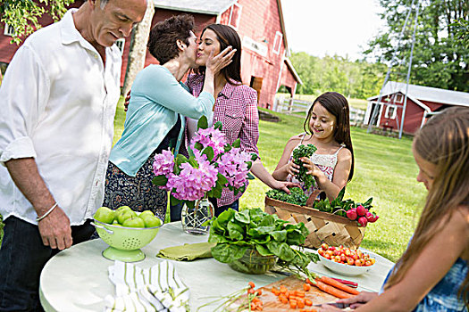 家庭聚会,桌子,沙拉,新鲜水果,蔬菜,父母,孩子,母亲,吻,女儿,脸颊