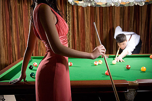 一對(duì)男女正在玩臺(tái)球