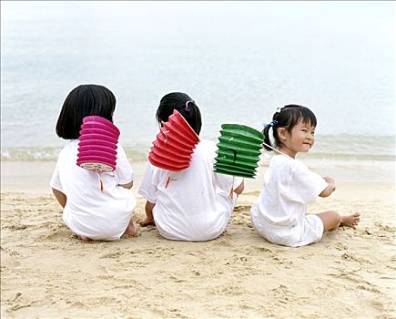 三个孩子,坐,海滩,拿着,灯笼,后视图
