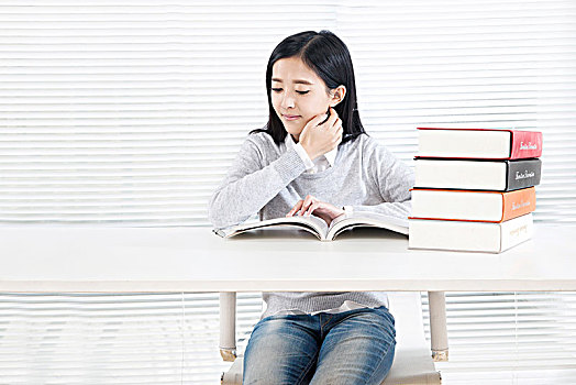 坐在桌子前学习的女大学生