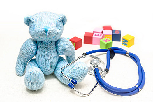 地板上泰迪熊毛绒玩具,听诊器与积木,寓意儿童健康,医疗保健概创意图