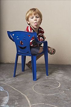 男孩,坐,椅子,伸舌头