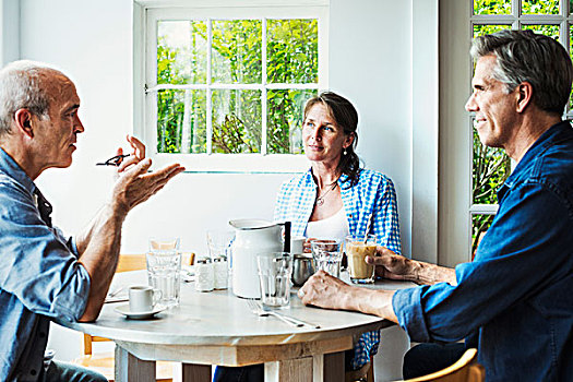 两个男人,女人,坐,咖啡馆,桌子,交谈