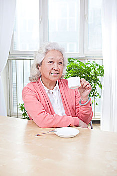 老年女士拿着茶水杯