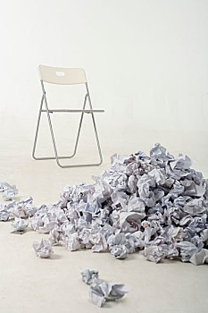 做废的草稿纸和椅子