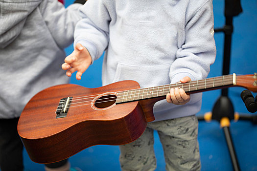 一群小孩在室外公園,學習彈吉他,玩著乌克丽丽