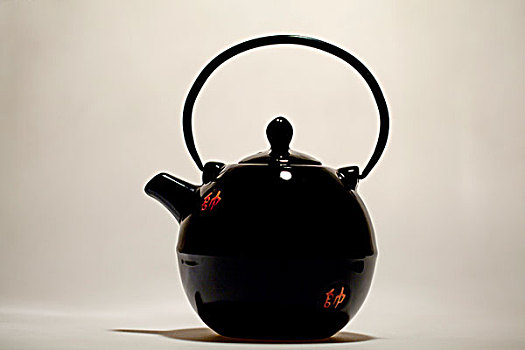 白色背景下平视具有中国传统特色的黑釉陶瓷茶壶