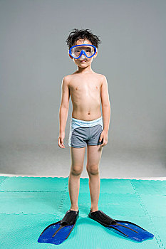 穿着游泳衣戴着潜水镜对着镜头玩耍的儿童