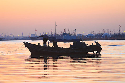 山东省日照市,渔民迎着初升的太阳出海捕鱼