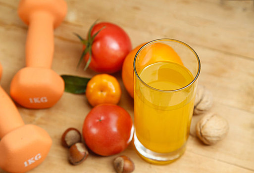哑铃,橙汁,水果和干果放在木桌上