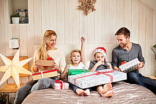 家庭,两个,成年人,两个孩子,坐,床上,圣诞节,开着,礼物,一起