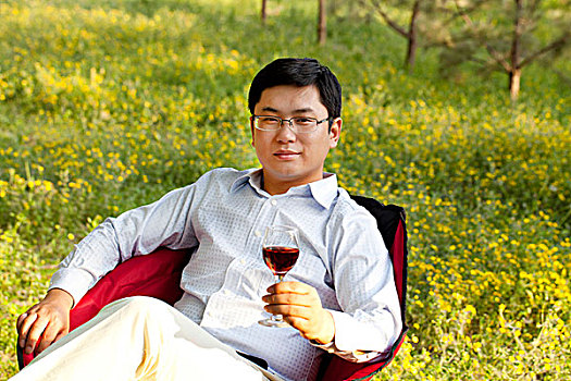 郊外坐在椅子上欣赏红酒的商务人士