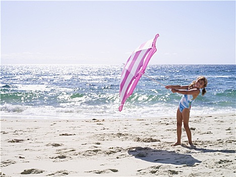 女孩,7-9岁,泳衣,玩,粉色,伞,沙滩,靠近,水,边缘,微笑,侧面视角,头像