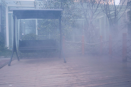 雾气笼罩下的花园秋千椅