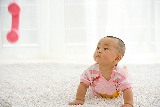 一个在地毯上玩耍的婴儿