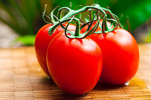 新鲜的西红柿在木质的砧板上,阳光下更加自然和美味