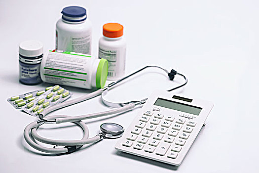 计算器,听诊器,胶囊和药瓶放在白色背景上
