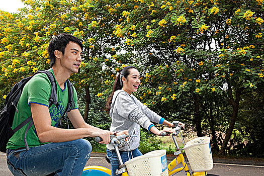 年轻大学生在校园里骑车