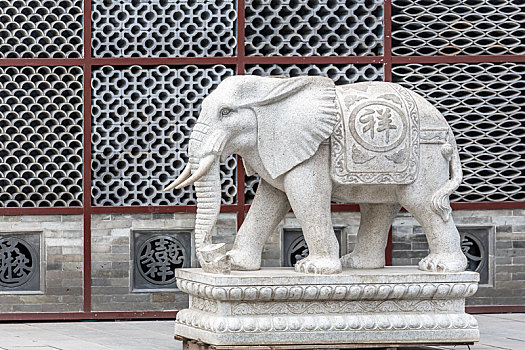 瓦当背景墙前面的一尊大象石雕
