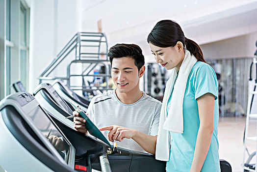年輕男子和女子在健身房健身