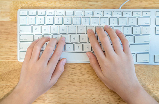 女孩双手放在电脑键盘上正在打字