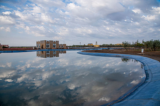新疆吉木萨尔县一在建景区水池中的彩云倒影