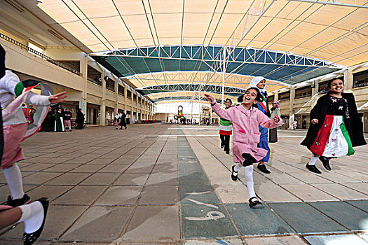 kuwait,city,young,girls,running,with,smile,and,dress,flag,from