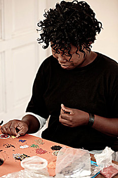年轻的非洲妇女,做,珠饰细工,在书桌