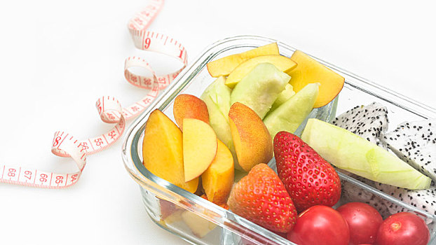 切好的各种水果组合由玻璃容器盛放,放在白色背景上