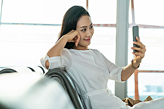 年轻女子在候机室使用手机