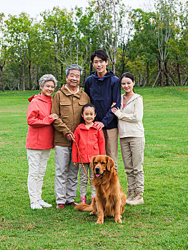 快乐的五口之家和宠物狗在公园合影