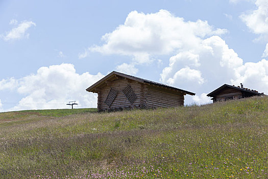 高山草原牧场上的小木屋,意大利多洛米蒂山区夏季苏西高原草甸和山峰自然风景