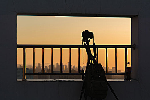 夕阳下的城市风光天际线和相机镜头剪影轮廓