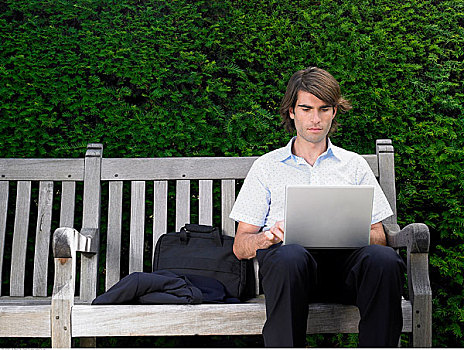 男人,坐,公园长椅,使用笔记本