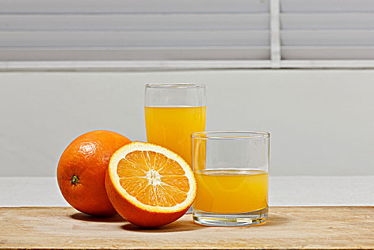 一个完整的橙子和两杯橙汁