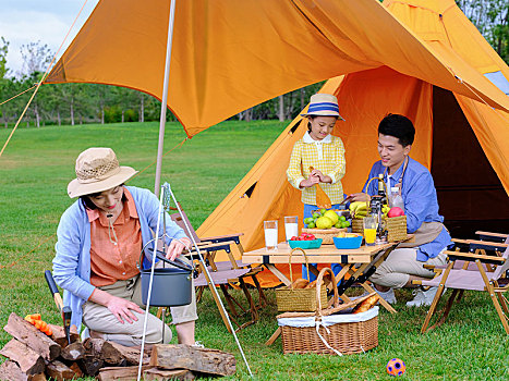 快乐的三口之家在户外露营做饭